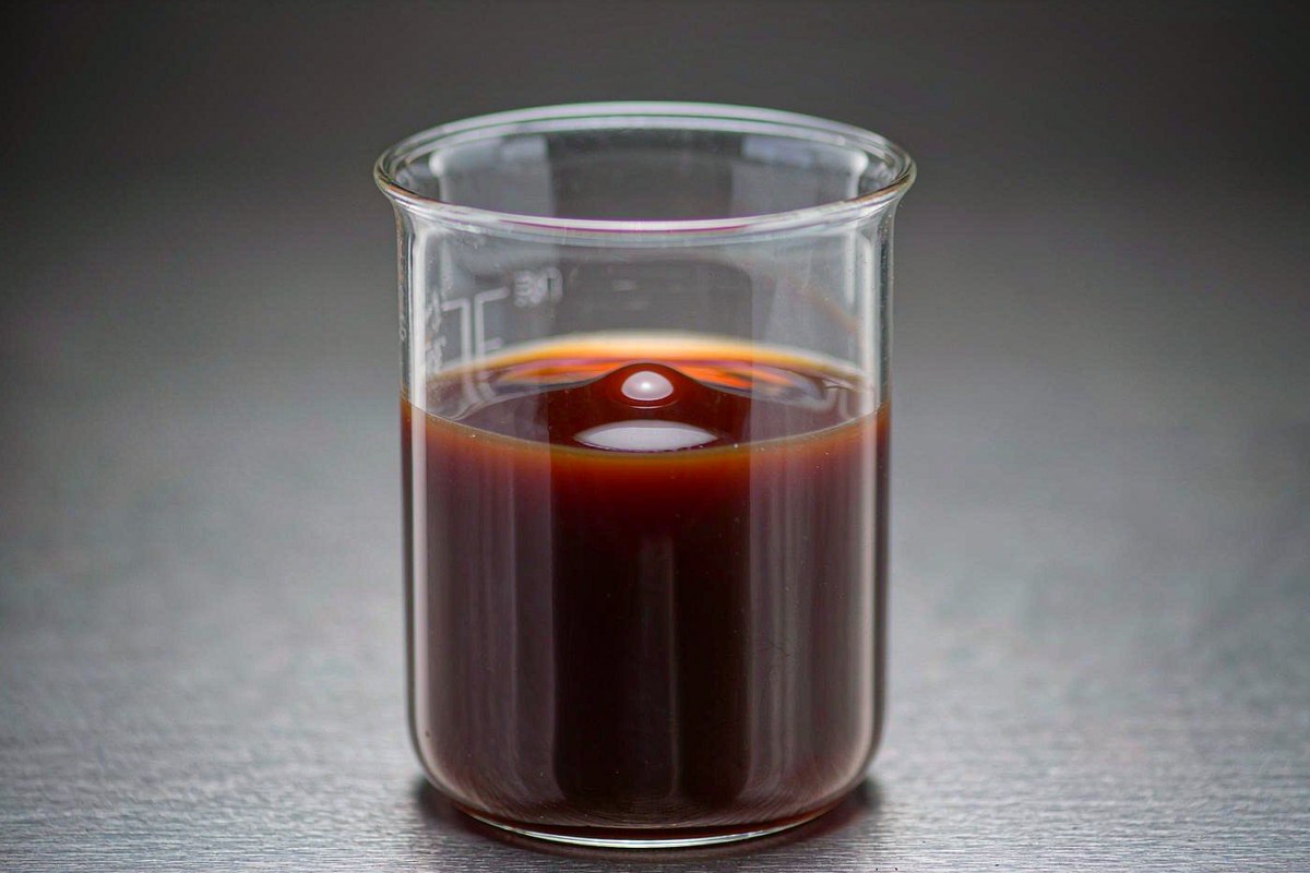 Cardanol diglycidyl ether YLD-9014A amber liquid sample in a laboratory glass beaker